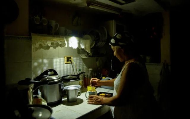 A person prepares coffee in the dark