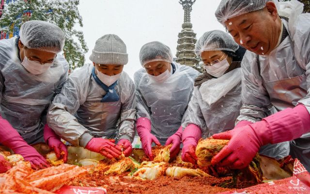 Participants prepare kimchi in an event amid snowfall at the Jogyesa Temple